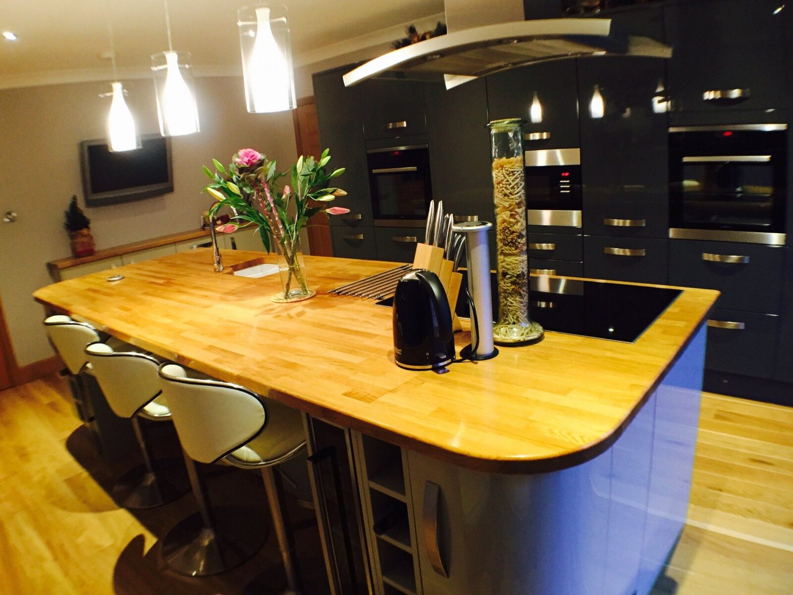 Kitchen island with oak worktop and pendant lights